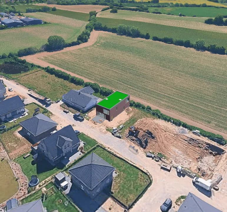 Ausgangsbild am Ortsrand: der Baukörper steht zwischen Bestandshäusern, Baugruben und angrenzenden Feldern.